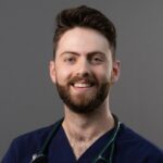 male veterinarian with short auburn hair, beard, and mustache